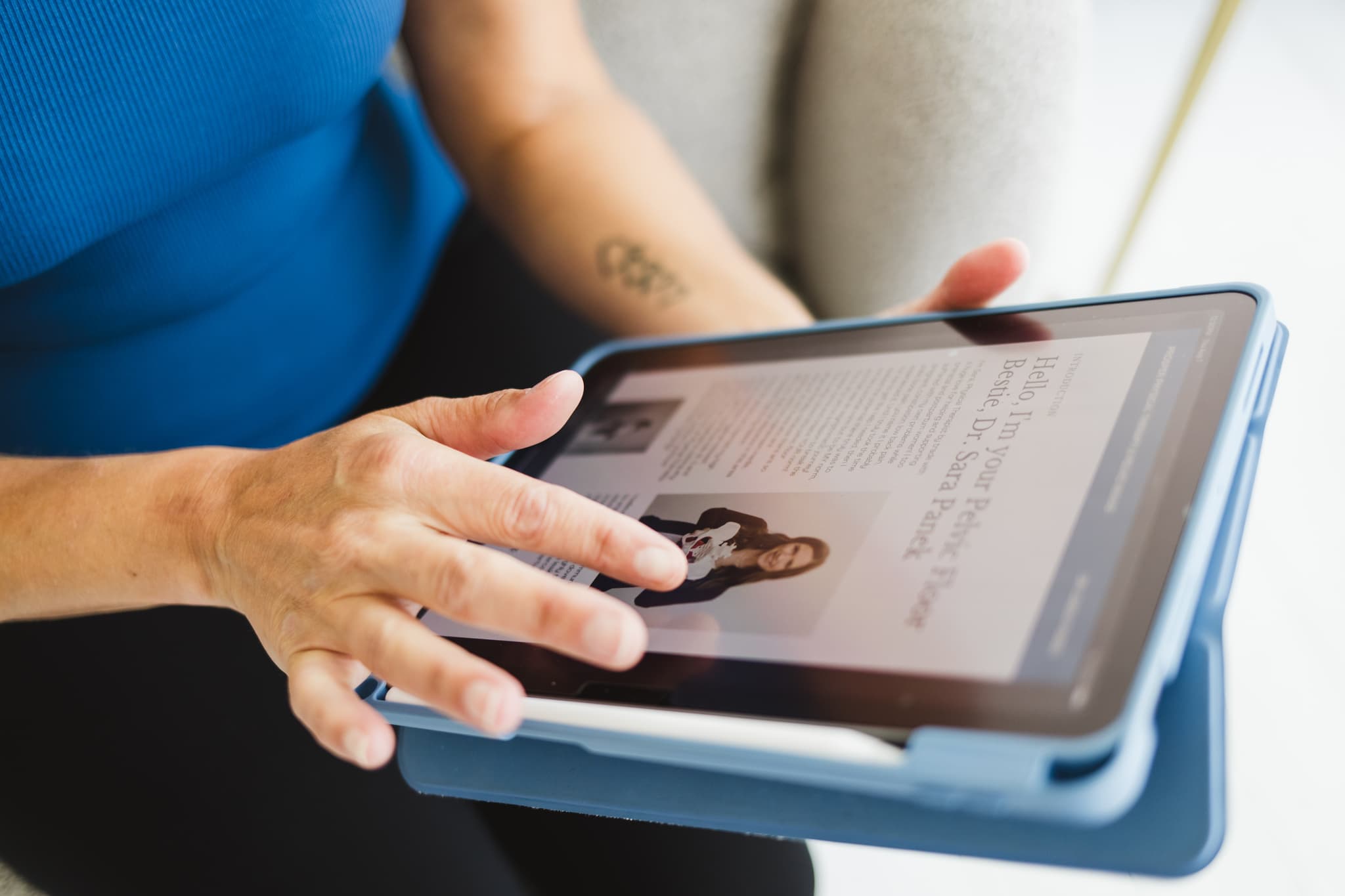 Detail image of a woman scrolling on an iPad of an eBook that she is reading about the pelvic floor physical therapy services she will be receiving.