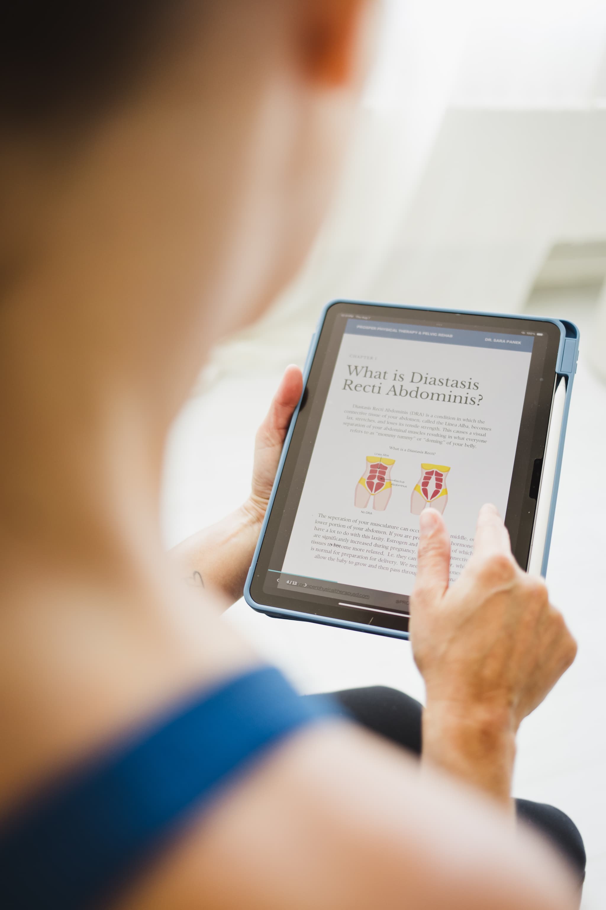 Image over the shoulder of a patient with focus on the iPad the patient is holding that is talking about ab separation.